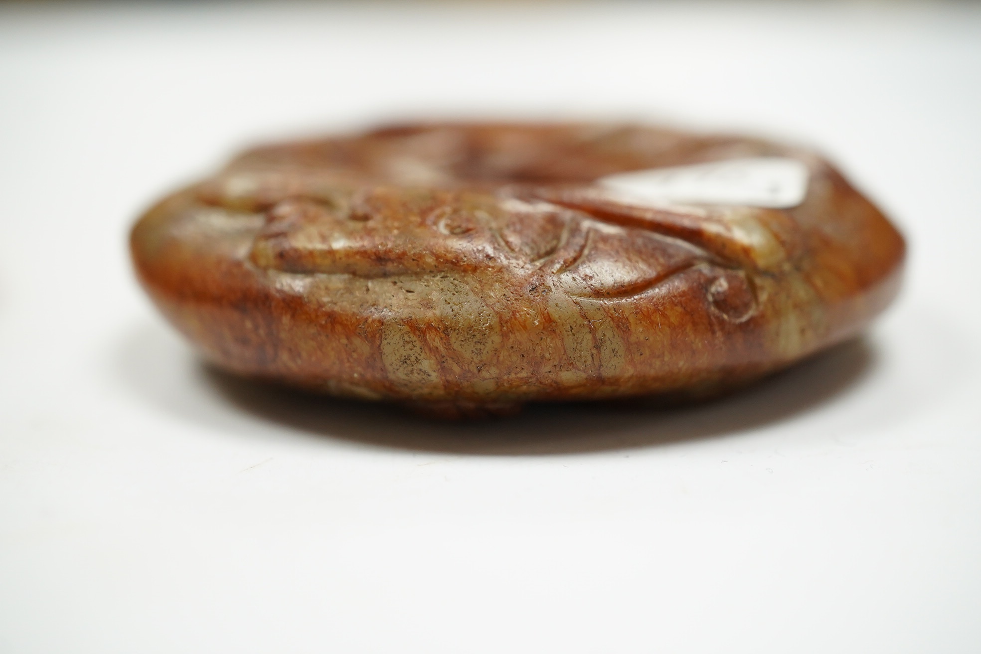 A Chinese russet and green jade bi disc and another plaque, largest 7cm diameter. Condition - good